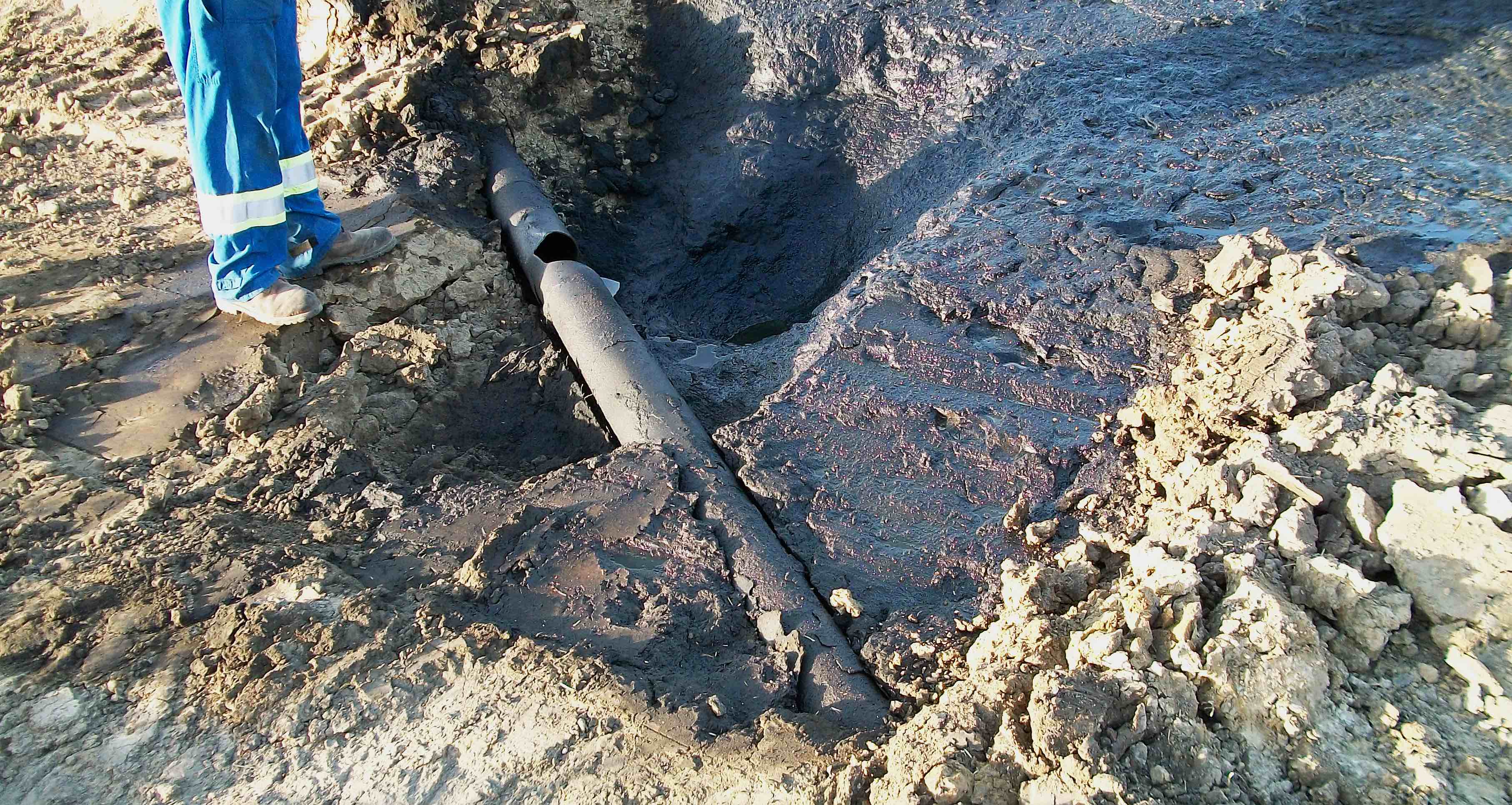 Exposed cracked pipeline in the ground