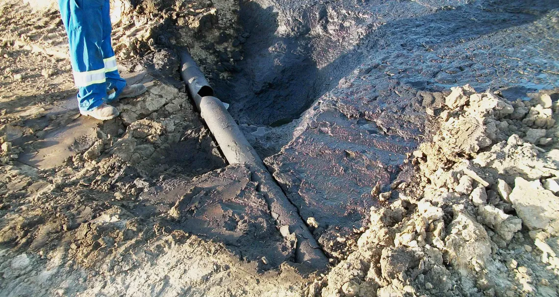Exposed cracked pipeline in the ground